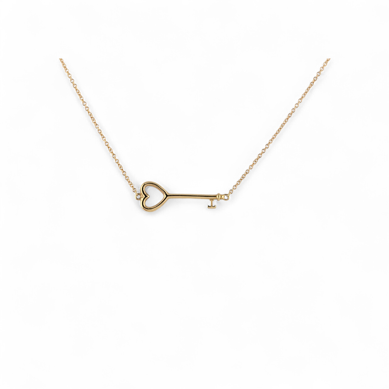 18KT YELLOW GOLD TIFFANY & CO EAST-WEST HEART KEY PENDANT NECKLACE.