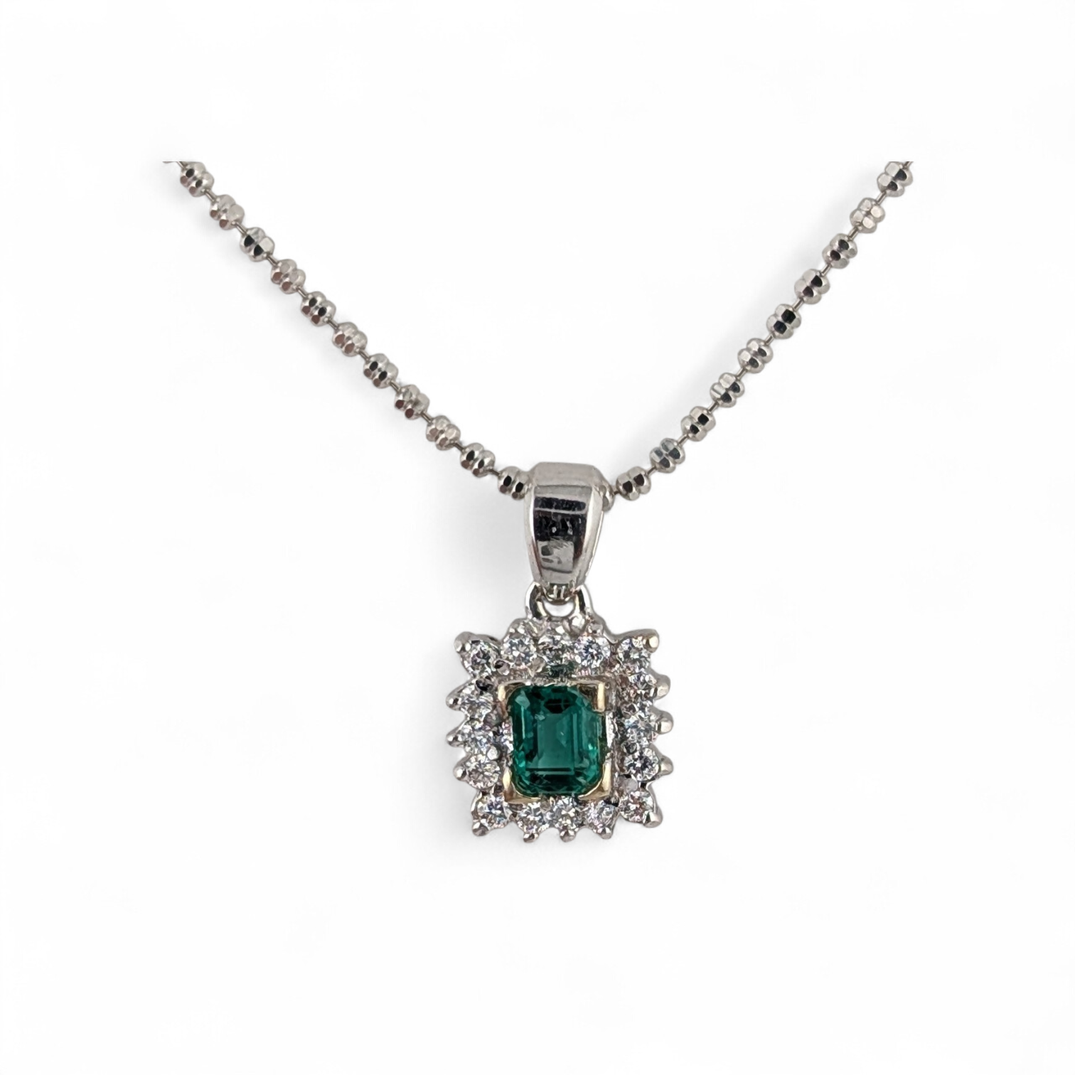 18KT WHITE GOLD EMERALD AND DIAMOND PENDANT AND CHAIN.